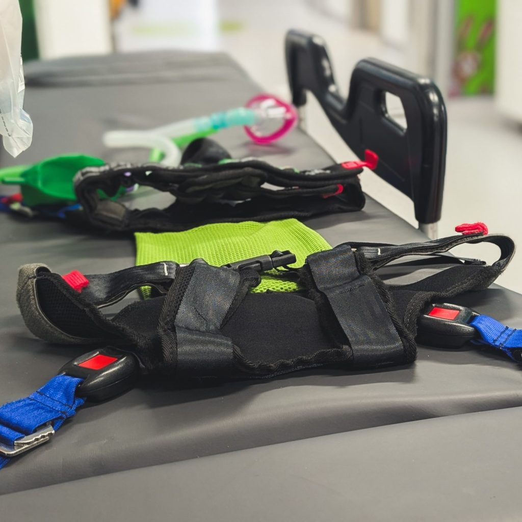 Large size Ambulance Child Restraint (ACR) harness on top of paediatric ferno transport trolley