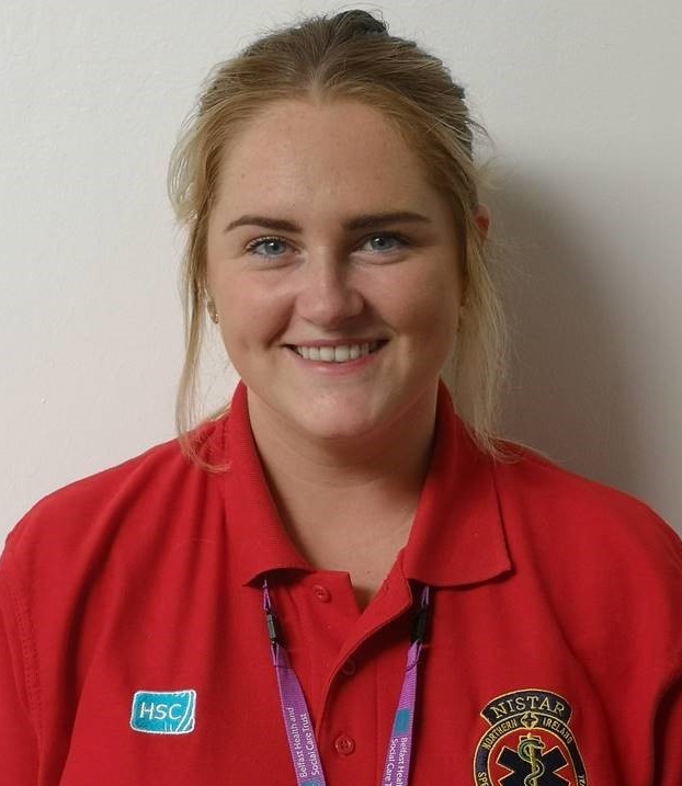 Admin support officer Ciara Reilly standing against white wall for profile