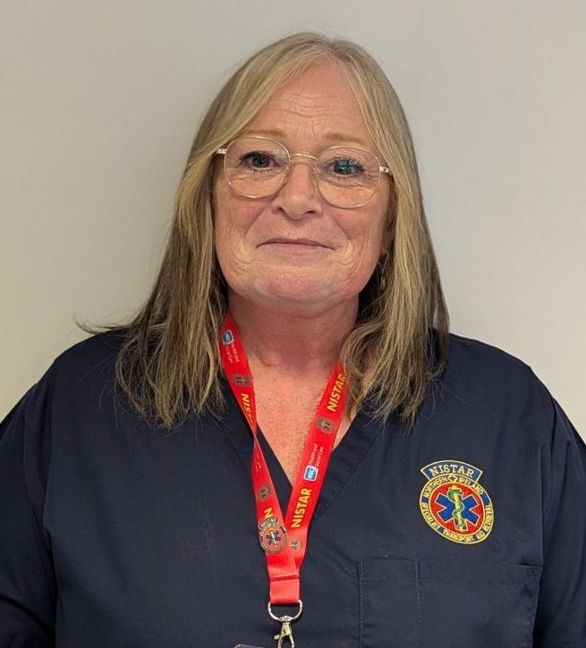 Headshot of Linda Kelly standing against a white wall